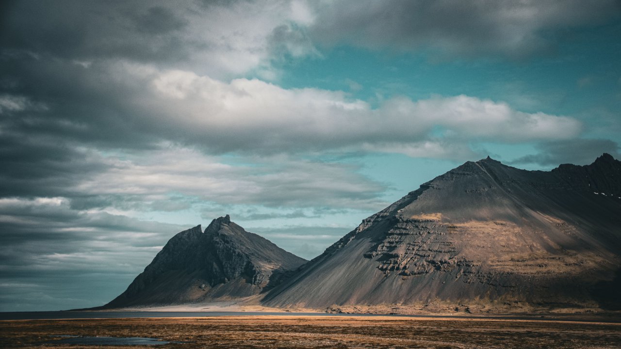 Bold cinematic mountain landscape under a cloudy sky