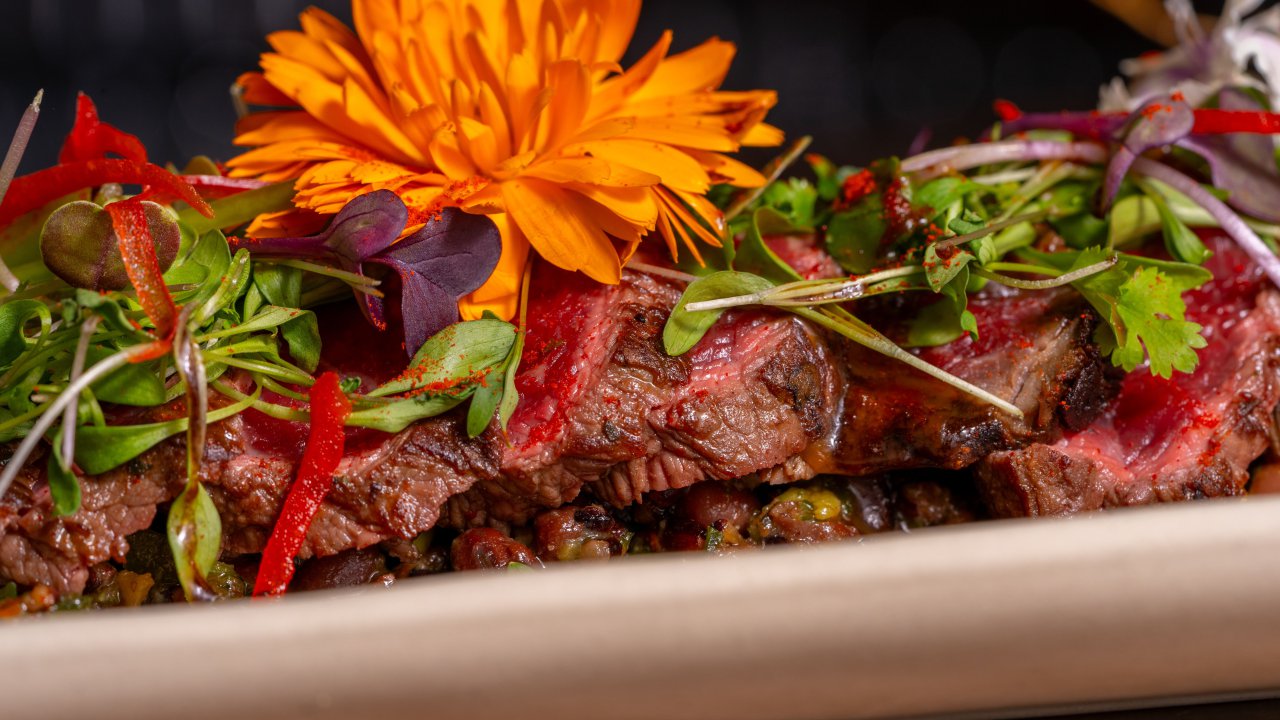 Gourmet steak dish garnished with an edible flower at a fine dining restaurant