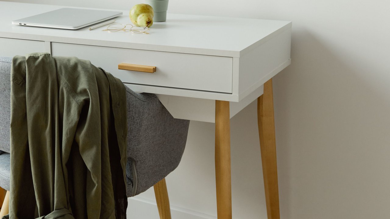 Minimalist clean workspace with a white desk and wooden floor
