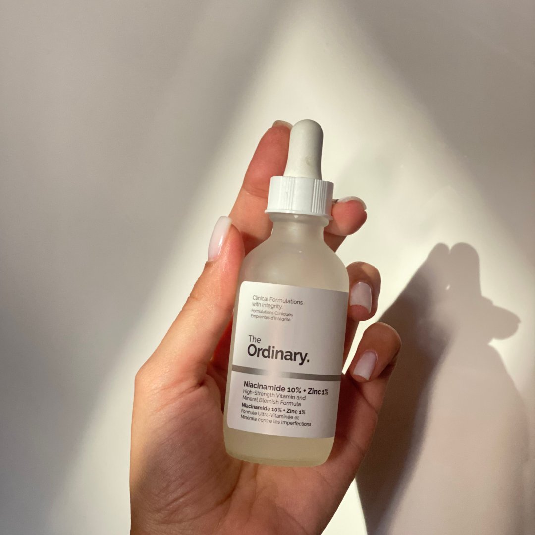 Hand holding a skincare serum bottle